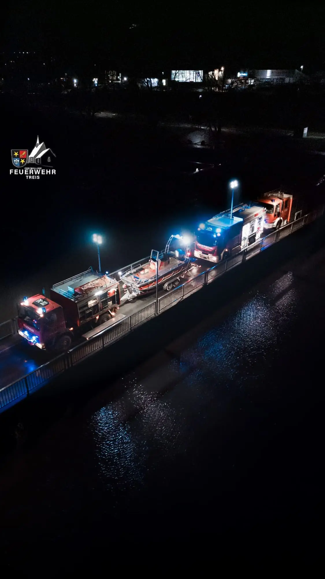 Fahrzeuge der Feuerwehr Treis mit Rettungsboot auf der Treiser Moselbrücke bei Nacht